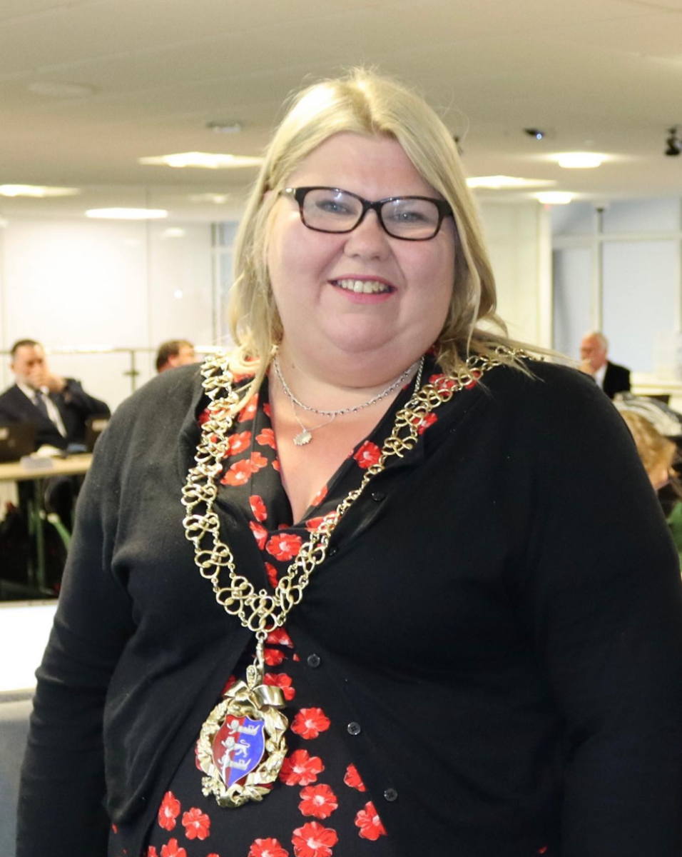 A photo of a woman with blonde hair, with a mayor's chain around her neck